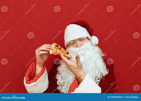 Closeup Portrait Of Santa Claus With Slice Of Pizza In Hands With