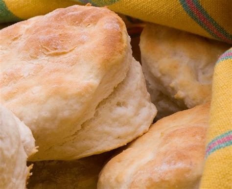 Some Biscuits Are Laying On Top Of A Yellow Towel With A Plaid Cloth Around Them