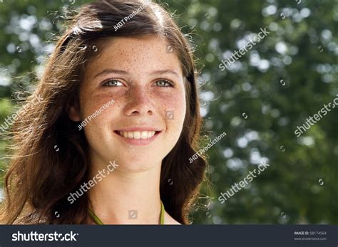 A Lovely Smiling Freckled Faced Teenage Girl With Sunlit