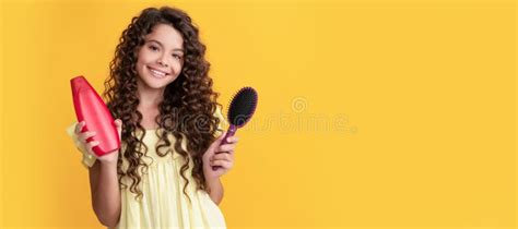 Happy Child With Long Curly Hair Hold Shampoo Bottle And Hairbrush Kid