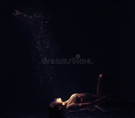 Underwater Shoot Of Beautiful Woman Swimming And Relaxing In Water In Sunbeams Stock Image