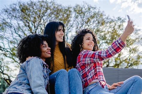 Premium Photo Three Multiracial Girlfriends Taking A Selfie In A City Park