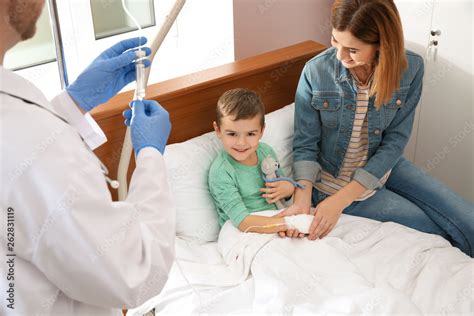 Foto De Doctor Adjusting Intravenous Drip For Little Child In Hospital