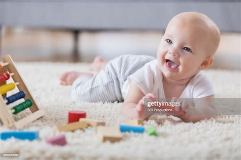 Cute Baby Sings With Open Mouth While Playing With Wooden Blocks High