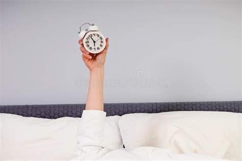 Hand Stick Out Under The Blanket Showing Alarm Clock Stock Image
