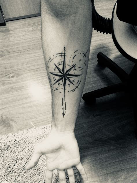 A Man With A Compass Tattoo On His Arm