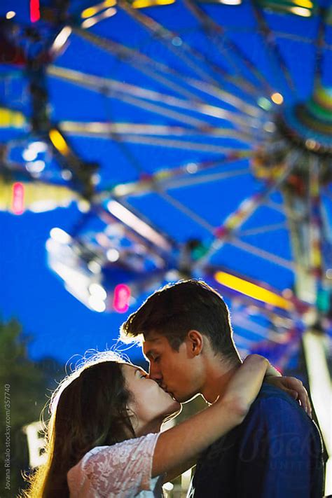 Young Couple Kissing At The Carnival By Jovana Rikalo Stocksy United