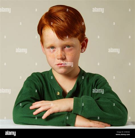 A Serious 5 Year Old Red Headed Caucasian Boy In A Green Shirt From