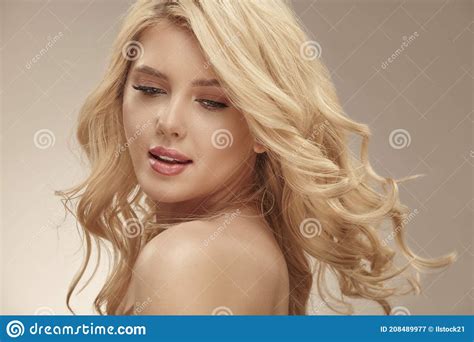 Pretty Young Blonde Woman With Nude Makeup Has A Curly Long Bright Hair