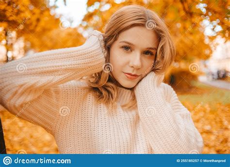 Photo Portrait Of A Girl In A White Sweater The Blonde Holds The Neck