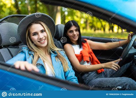 Two Friends Women On Road Trip Driving In Convertible Car Stock Photo