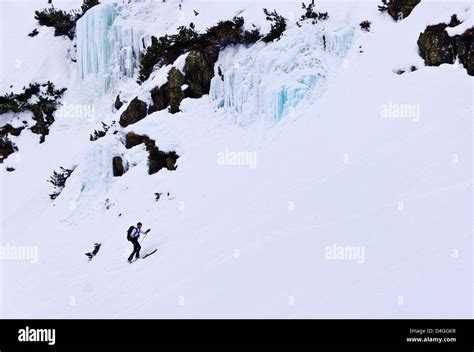 Ski Alpinist Ascending A Slope Under A Frozen Waterfall Stubai Alps