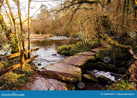 English Countryside With An Old Stone Bridge Across A River In A Forest