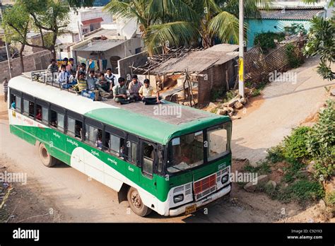 Indian Bus Traveling Along A Rural Indian Village Road With Teenage