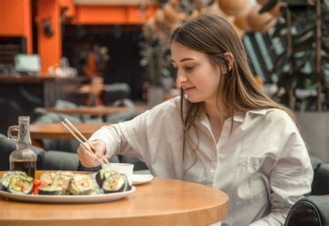Mujer Joven Comiendo Y Disfrutando Sushi Fresco Foto Premium