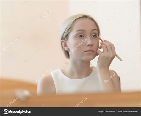 Woman Looking In Mirror While Applying Makeup — Stock Photo © Eevl