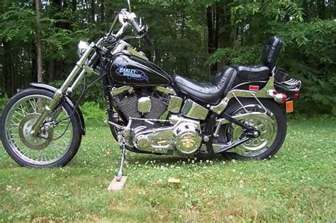 Lowered fatboy style front end, handmade custom handlebar with custom handlebar control kit, satin finish rear fender tail section from a flathead fender, firestone rear tire and avon speedmaster on the front wheel, harley factory floating brakes rotors, knucklehead chrome headlight shell with amber glass. 1988 Harley-Davidson® FXSTC Softail® Custom (Black), Homer ...