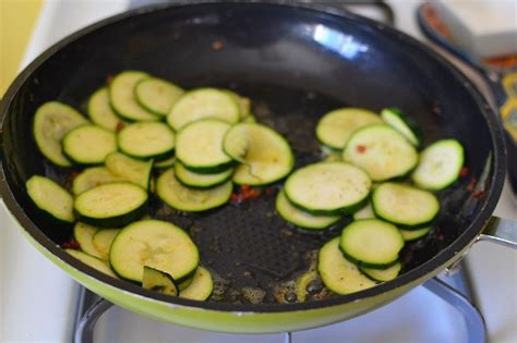 Sliced Zucchini Being Cooked In A Pan On The Stove