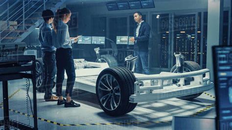 Automotive Design Engineers Talking While Working On Electric Car