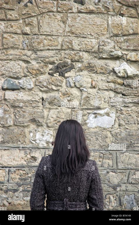 Young Woman Facing Stone Wall Stock Photo Alamy