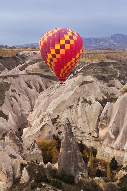 Premium Photo Hot Air Balloon Flying Over Rock Landscape At