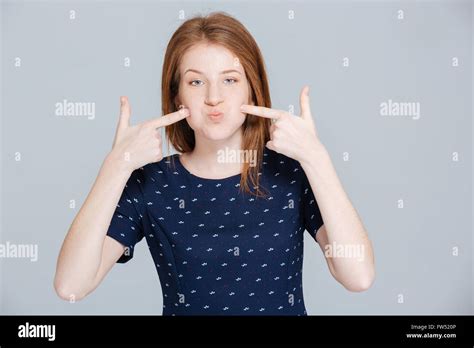 Young Woman Puffed Out Her Cheeks Over Gray Background Stock Photo Alamy