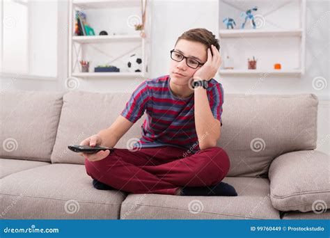 Boy Watching Tv And Looking Bored On Couch At Home Stock Image Image