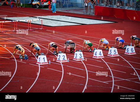 Female Sprinters Lined Up At The Starting Blocks For The 100m Race