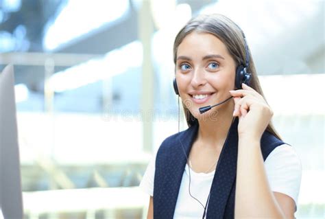 Beautiful Young Female Call Center Operator With Headset In Office