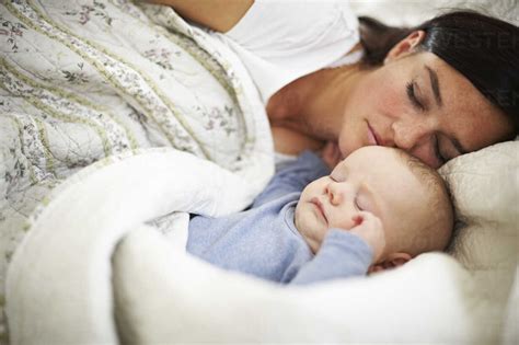 Mother And Baby Sleeping In Bed Stock Photo