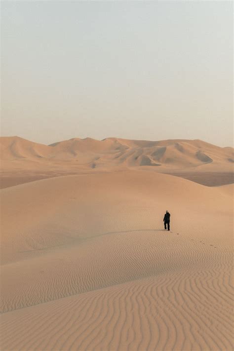 Person Walking On Desert During Daytime Photo Free Soil Image On