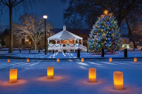 Lighted Candles Are In The Snow Near A Lit Christmas Tree And Gazebo At