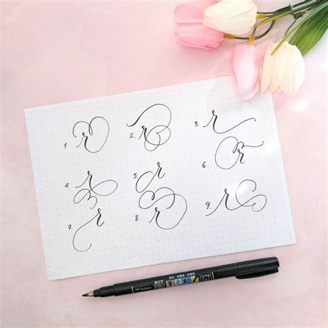 A Pen And Some Flowers On Top Of A Sheet Of Paper With Cursive Writing