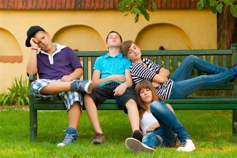 Bored Teenagers Sitting And Lying On The Bench Royalty Free Stock