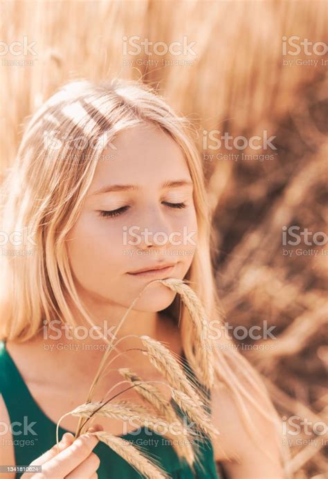 Beautiful Teenage Girl With Long White Hair Walking Through A Wheat