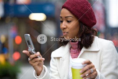 An Attractive African American Business Woman Checks Her Cell Phone In