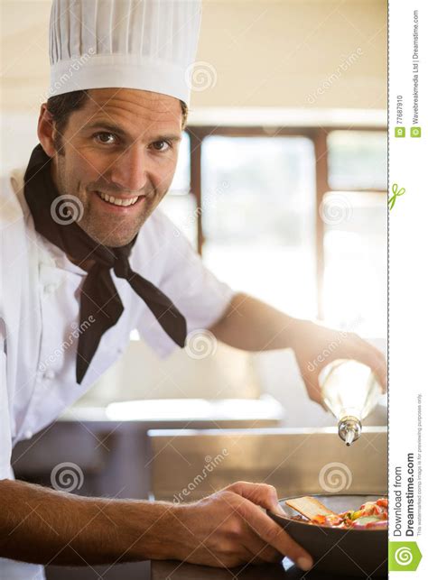 Portrait Of Happy Chef Pouring Olive Oil On Salad Stock Photo Image