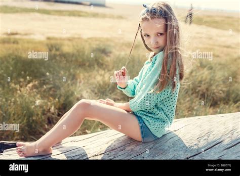 Pretty Little Girl Relaxing On The Beach Near Sea Summer Vacation