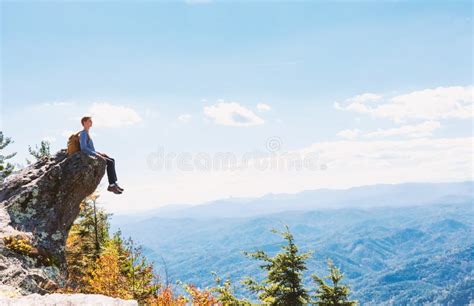 Man Sitting On The Edge Of A Cliff Overlooking Stock Image Image Of