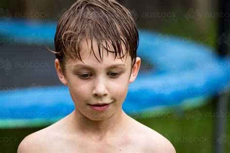 Seven Year Old Boy Looking Content With Wet Hair Looking Down In