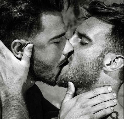 Two Men Are Kissing Each Other With Their Hands On Their Chests And One Is Holding His Face To