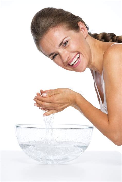 Smiling Young Woman Washing Face In Glass Bowl With Water Stock Photo