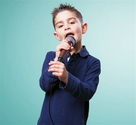 Niño Adorable Cantando Con Un Micrófono Descargar Fotos Gratis