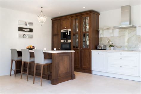 That's why the kitchen needs to be ivniting and airy, to give a feeling and cozyness and cleanness. Traditional white kitchen with walnut island and pantry - Stoneham Kitchens