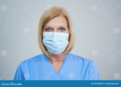 Senior Female Doctor Posing In Mask Over Gray Background Stock Photo