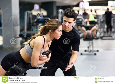 Personal Trainer Helping Young Woman Lift Weights Stock Photo Image