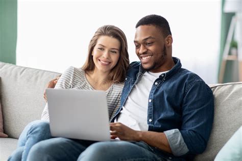 Weekend Pastime Interracial Couple With Laptop Relaxing On Couch In