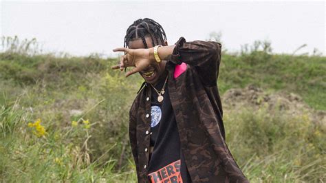 Travis Scott Is Closing Eyes With Hand Wearing Brown And Black Dress