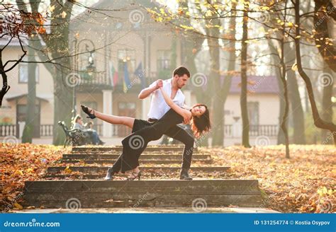 Young Elegant Couple Passionately Dancing Tango In City Park Stock