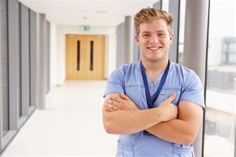 Portrait Of Male Nurse Standing In Hospital Corridor Nursing